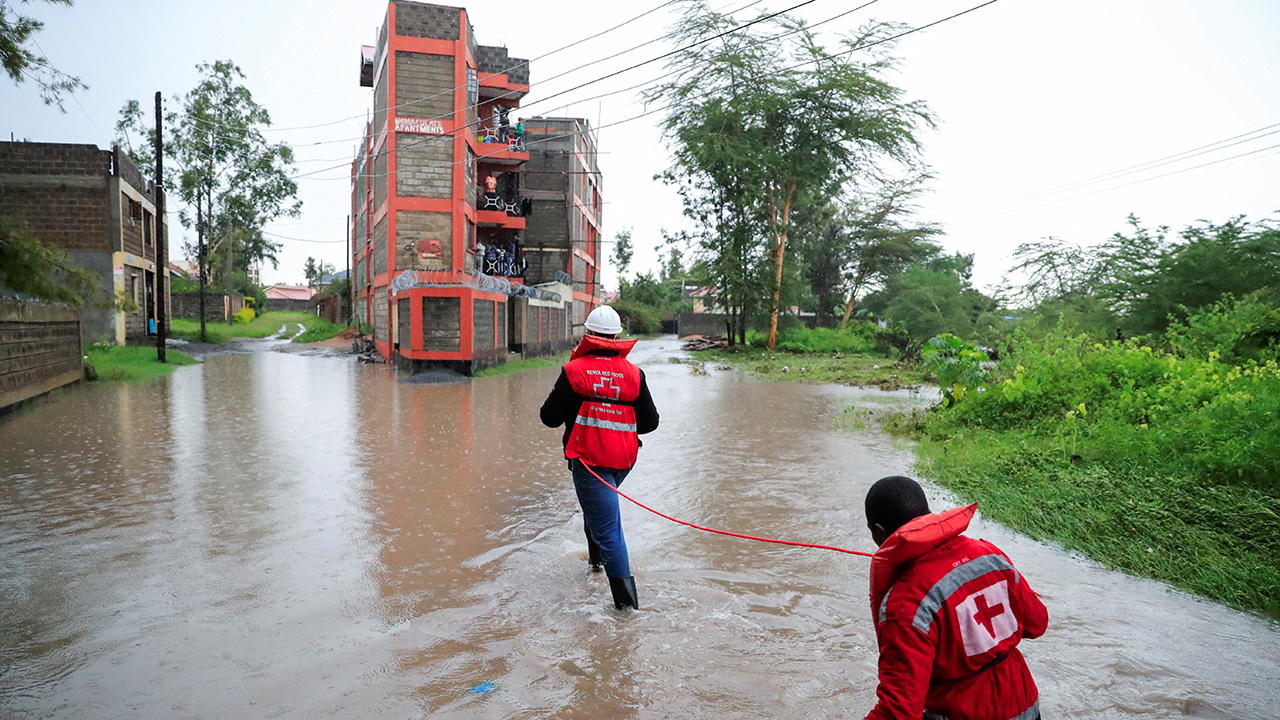 Kenya Red Cross members holding on to a safety rope during flood.