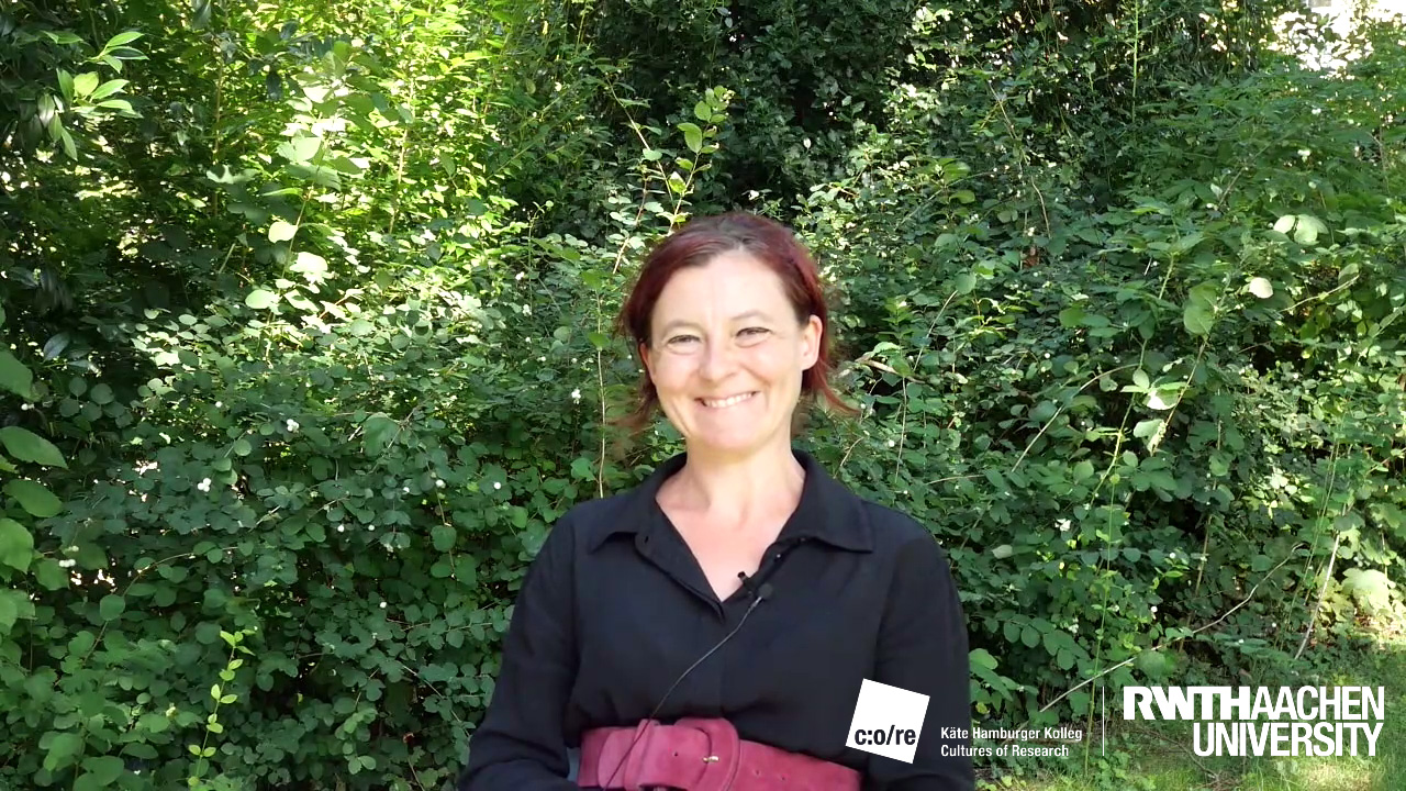 Woman wearing black shirt smiling outdoors.